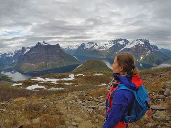 Rear view of woman on snowcapped mountains against sky