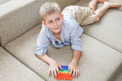 High angle view portrait of boy on sofa