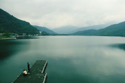 Scenic view of calm lake against cloudy sky