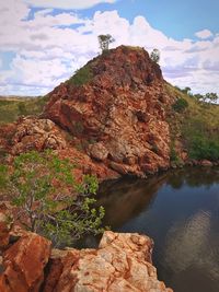 Rock formation by sea against sky