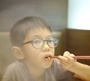 Close-up portrait of boy holding eyeglasses