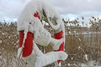 Close-up of snow on field against sky