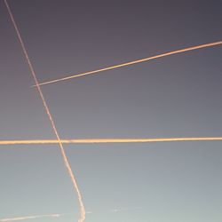 Low angle view of vapor trails against sky