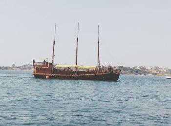 Ship sailing on sea against clear sky