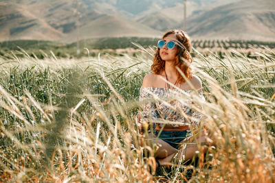 Young woman wearing sunglasses on field