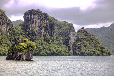 Scenic view of mountain by sea against sky