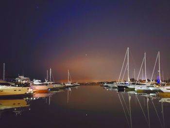 Boats moored in harbor at night