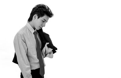 Full length of young man standing against white background