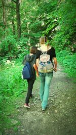 Rear view of young woman walking in forest