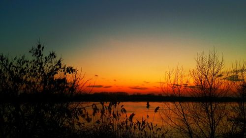 Scenic view of lake against romantic sky at sunset