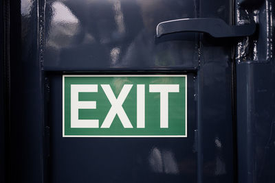 Exit sign on black metal door