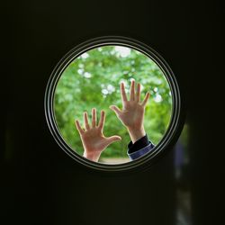 Silhouette hands touching round window