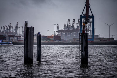 Ship moored at harbor against sky in city