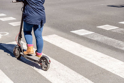 Low section of man riding bicycle on road