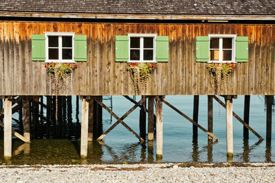 Wooden posts in sea against house