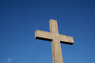 Low angle view of cross against clear blue sky