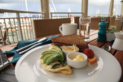 Egg white omelet with spinach, avocado slices and cheese along with wheat toast for breakfast