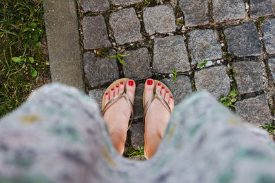 Low section of woman standing on footpath