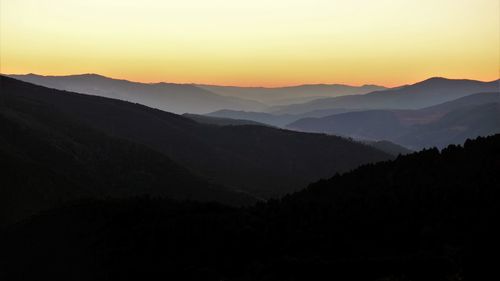 Scenic view of silhouette mountains against sky during sunset