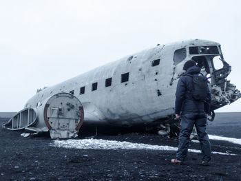 Full length of man on airplane against sky during winter