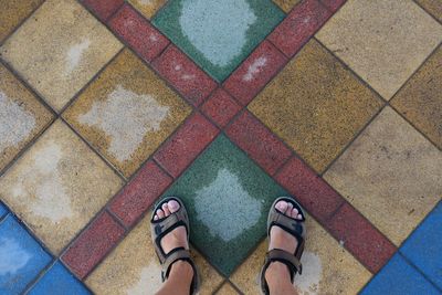 Low section of man standing on tiled floor