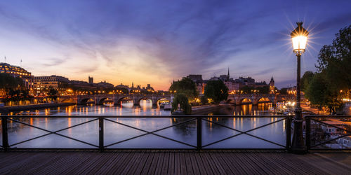 Illuminated buildings against sky at sunset