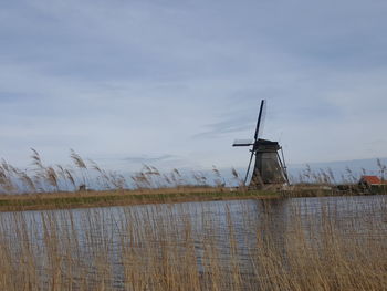 Traditional windmill on field against sky