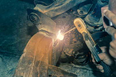 Midsection of man working on metal