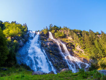 Scenic view of waterfall against clear sky