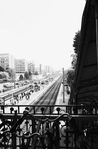 Railroad tracks in city against clear sky