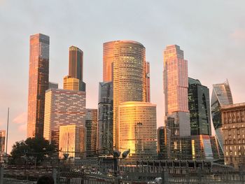 Low angle view of illuminated buildings against sky in city