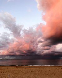 Scenic view of sea against dramatic sky during sunset
