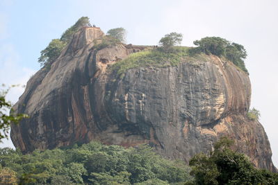 Low angle view of rock formation on mountain against sky