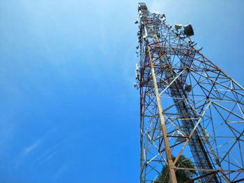 Low angle view of communications tower against blue sky