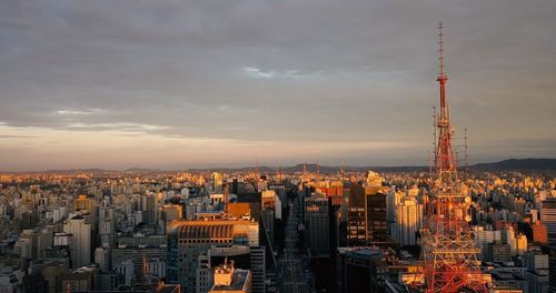 Aerial view of buildings against cloudy sky