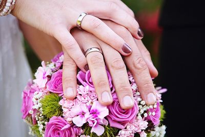 Cropped image of hands holding bouquet