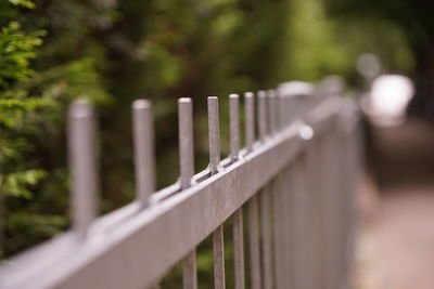 Close-up of railing by fence