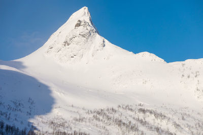 Scenic view of snowcapped mountain against blue sky