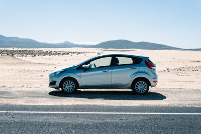 Side view of car on road against clear sky