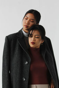Close-up of young couple standing against white background