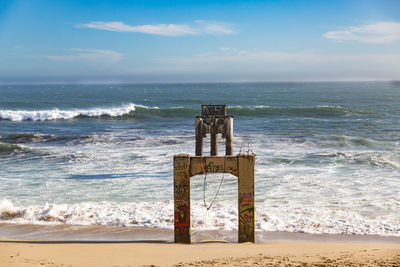 Lifeguard hut on beach against sky