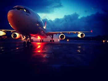 Airplane on runway against sky at night