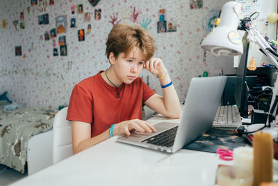 Teenage girl studying remotely using a laptop. online education. e-learning