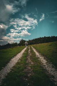 People walking on field against sky