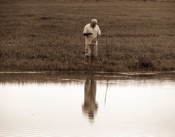 Rear view of woman standing in lake
