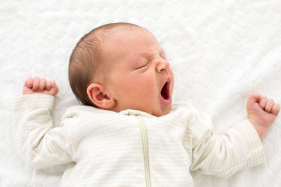 Portrait of cute baby boy sleeping on bed at home