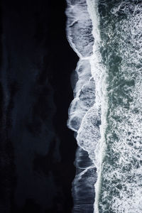 Aerial view of waves rushing towards shore