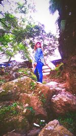 Woman standing on tree trunk