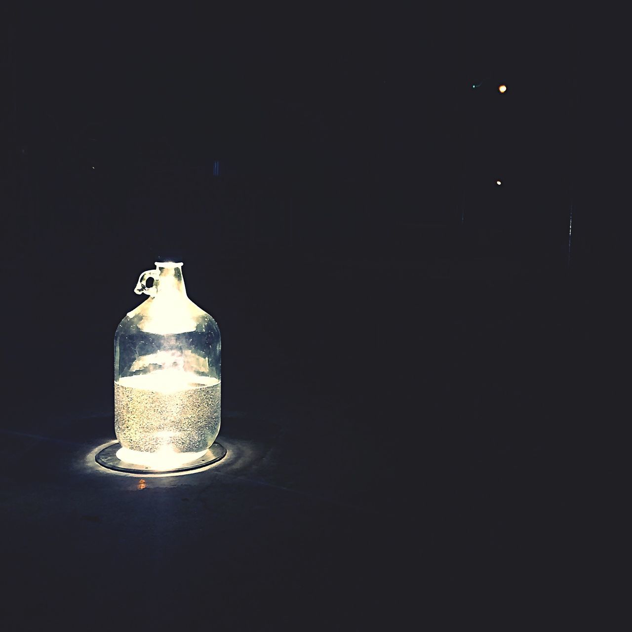 indoors, glass - material, close-up, drink, still life, food and drink, illuminated, drinking glass, studio shot, transparent, copy space, refreshment, burning, lighting equipment, glass, table, glowing, bottle, candle, no people