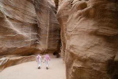 Two arab tourists walk through the siq in petra en route to the treasury